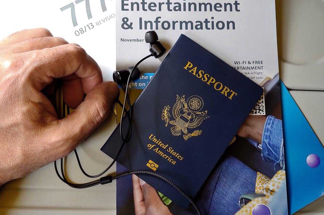 testimonial-image Close-up of US passport with inflight magazine and headphones on an airplane seat, ready for travel.